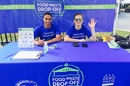 Young man and women working a booth for Food Waste Drop-Off